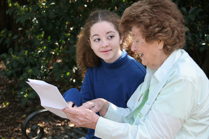 Older lady talking with her family member about information that is on the piece of paper that she is holding.