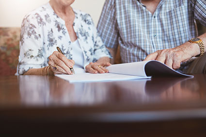 Elderly patient and younger woman looking face to face. smiling.