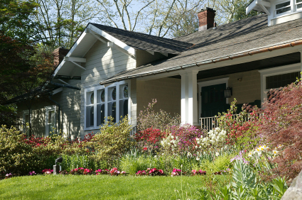 View of front of a house with beautiful flower landscape beds.